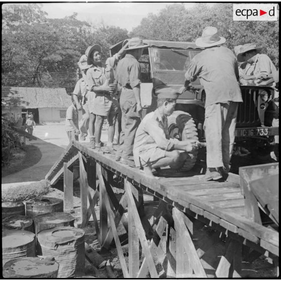 18 Des militaires de l'armée cambodgienne remettent en état une jeep sur un pont de réparation. [description provisoire]