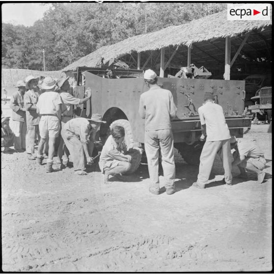 19 Des militaires de l'armée cambodgienne réparent et nettoient un scout car. [description provisoire]