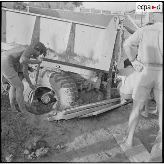 31 Un Cambodgien procède au dégagement d'un camion benne enlisé dans un chantier de construction du poste. [description provisoire]