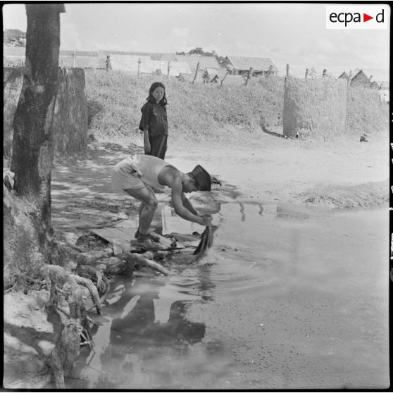 9 Un militaire cambodgien fait la lessive dans l'eau de la rivière, aux abords du poste. [description provisoire]