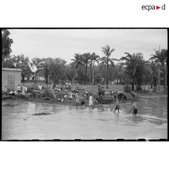 Habitants de Hué consolidant les berges après les inondations survenues les 16 et 17 juin 1953.