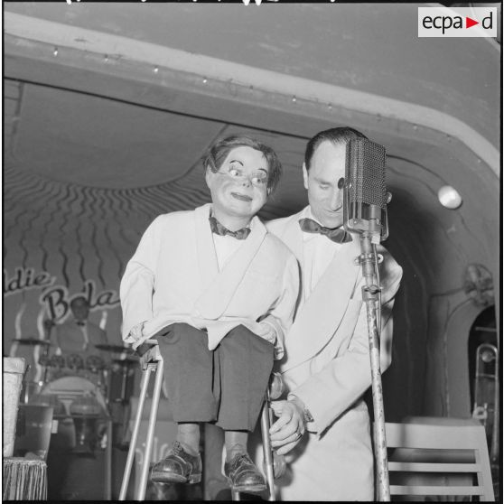 12 à 14 L'orchestre Eddie Bola : le présentateur ; le saxophoniste. [description provisoire]