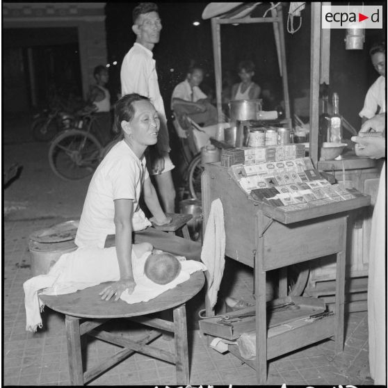 24 à 37 Petits commerçants et artisans cambodgiens en activité la nuit à Phnom Penh. [description provisoire]