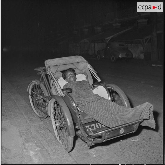 39 à 40 Cambodgien dormant la nuit dehors dans un cyclo-pousse. [description provisoire]