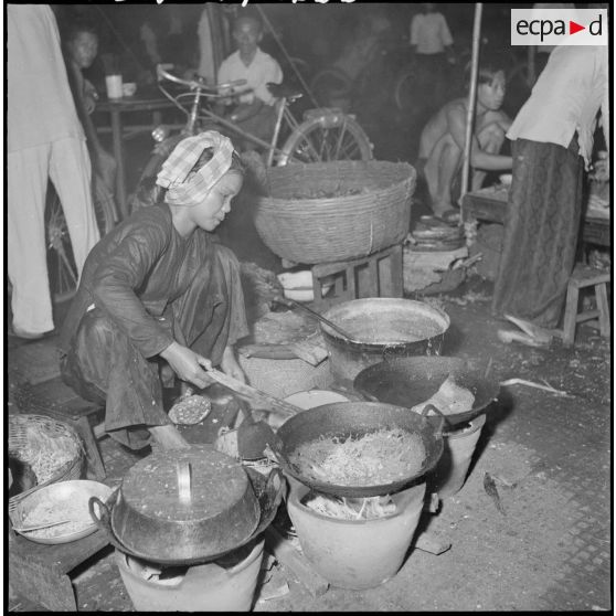 Une femme cambodgienne en train de cuisiner dans une rue de Phnom Penh. [description provisoire]