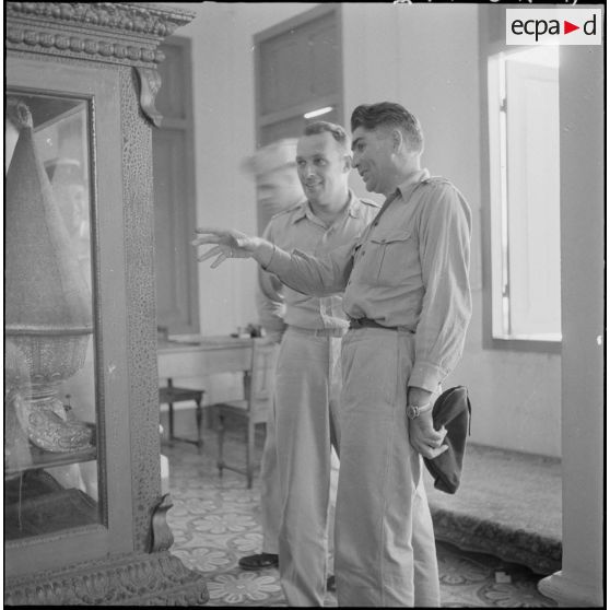 8 Au palais royal, le capitaine Oriol (à droite) montre les attributs royaux au lieutenant-colonel américain Glenn. [description provisoire]