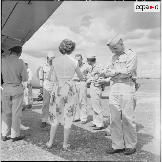 9 à 10 Avant leur départ pour Saigon en avion, les officiers américains écoutent un discours sur le terrain d'aviation. [description provisoire]