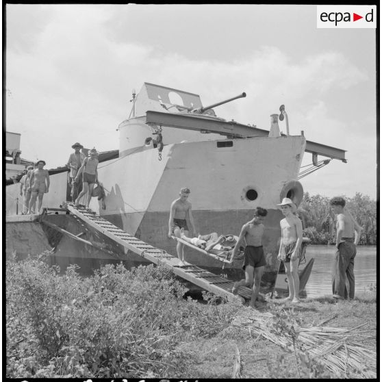 Des blessés sont évacués du LCI 106 vers l'antenne chirurgicale.