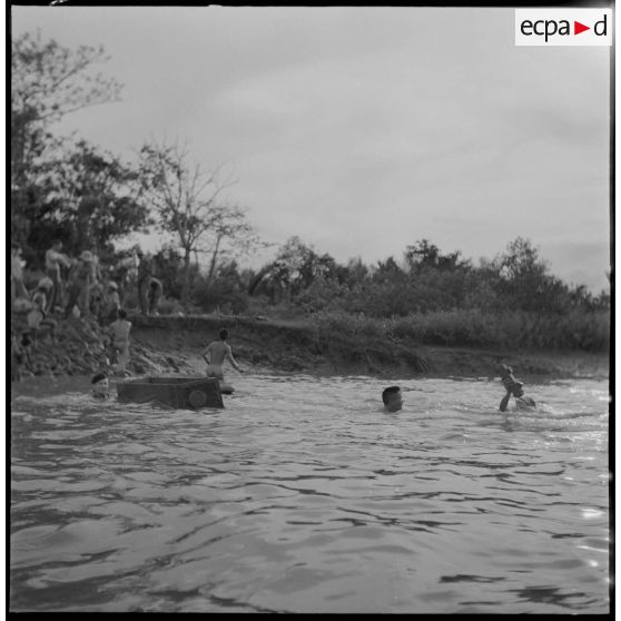 Le commando franco-vietnamien passe un rach à la nage près du Pu Bong, utilisant un cercueil pour transporter le matériel.