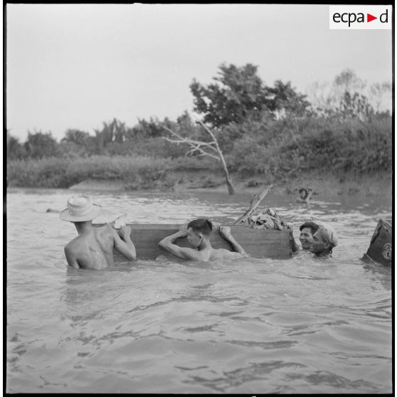Le commando franco-vietnamien passe un rach à la nage près du Pu Bong, utilisant un cercueil pour transporter le matériel.