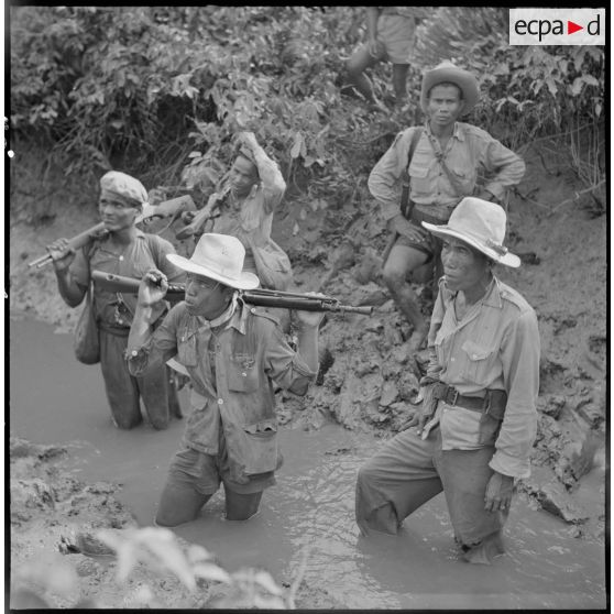 Dans la boue d'un arroyo, le commando franco-vietnamien attend que les éclaireurs trouvent un passage.