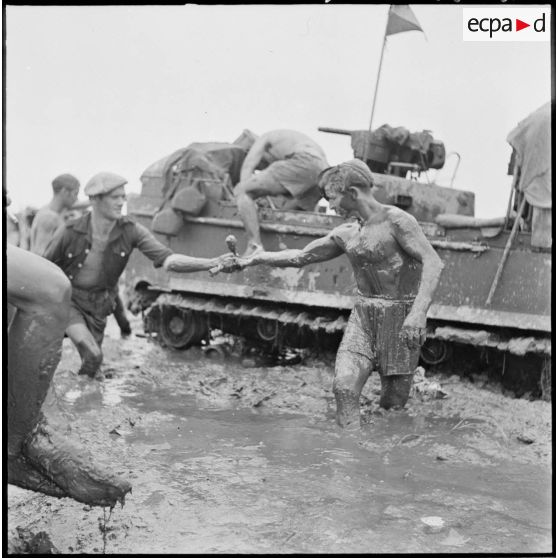 Un légionnaire du 1er régiment étranger de cavalerie sort couvert de boue et d'huile après avoir vidangé un engin amphibie M29 Weasel embourbé, au cours de l'opération Jeanne d'Arc. [description provisoire]