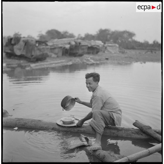 Corvée de vaisselle dans un point d'eau au cours de l'opération Jeanne d'Arc.