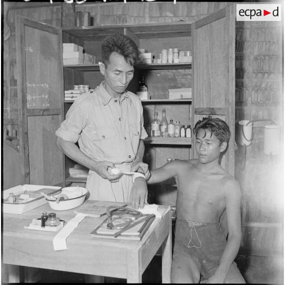 L'infirmerie du camp de Kompong Cham : un jeune prisonnier reçoit des soins. [description provisoire]