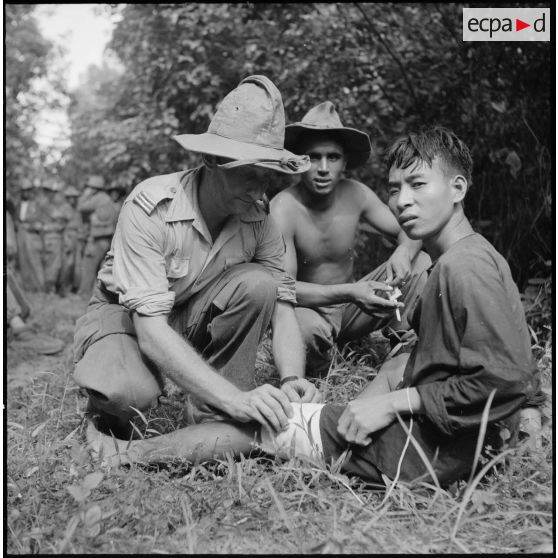 Au cours d'une halte, le médecin-capitaine Michel Bernard soigne un partisan du vietminh fait prisonnier au cours de l'opération Aspic. [description provisoire]