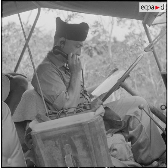 100 Le capitaine Le Duc, adjoint du commandant Marlic commandant l'opération, transmet un ordre par radio dans sa jeep. [description provisoire]
