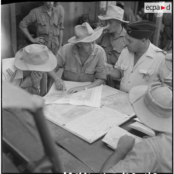 32 Devant les cartes étalées sur le capot de sa jeep, le commandant Marlic donne ses ordres pour la suite de l'opération [description provisoire]