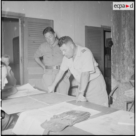 9 Le commandant Marlic, commandant le 2/6e RIC, penché sur une carte avec le capitaine Piolot,commandant le 5e BCC. [description provisoire]