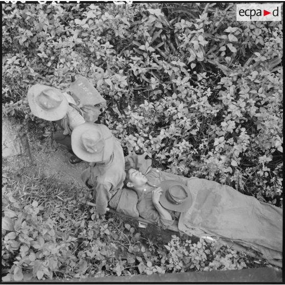 Evacuation sur un brancard d'un blessé du 43e régiment d'infanterie coloniale au cours de l'opération Mangouste. [description provisoire]