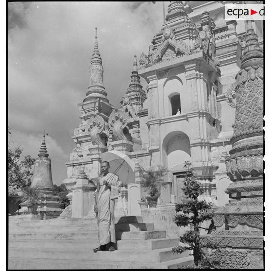 Bonze posant devant l'entrée monumentale de Wat Botum (pagode de la fleur de lotus) à Phnom Penh. [description provisoire]