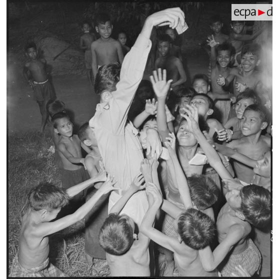 Un militaire français distribue des friandises aux enfants avant la cérémonie religieuse au Wat Botum de Phnom Penh. [description provisoire]