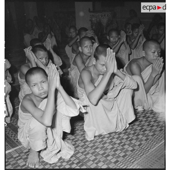 Assemblée de jeunes bonzes écoutant la lecture d'un texte sacré dans la pagode Wat Botum à Phnom Penh. [description provisoire]