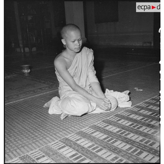 Jeune bonze en méditation après la lecture publique et psalmodiée de la Parole du maître. [description provisoire]