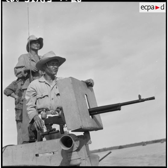 Servant d'une mitrailleuse sur une vedette blindée du 4e régiment de dragons sur la rivière de Saigon.