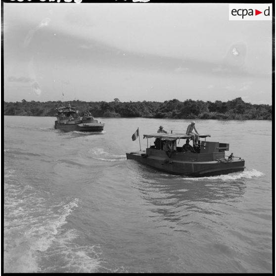 Une vedette du 4e régiment de dragons suivie d'un LCM Monitor escortant le convoi de jonques Michelin sur la rivière de Saigon.