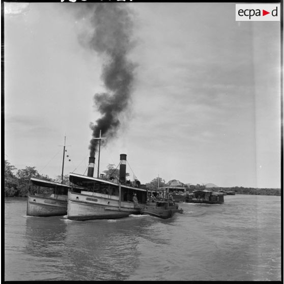 Transport de latex dans des jonques Michelin convoyées par des vedettes blindées du 4e régiment de dragons sur la rivière de Saigon au cours de l'opération Rivière. [description provisoire]