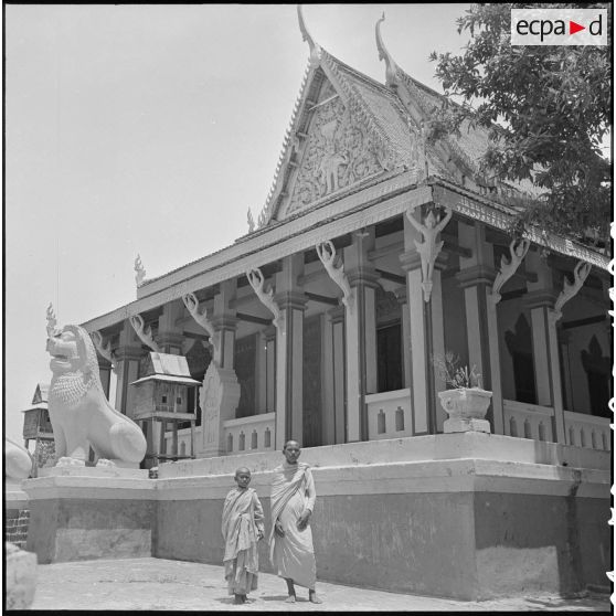 Façade du Wat Phnom de Phnom Penh devant lequel posent deux bonzes. [description provisoire]
