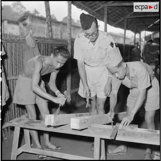 Menuisiers au travail sous la direction de l'adjudant Gros au camp d'instruction de l'Armée nationale vietnamienne n°2 de Soctrang. [description provisoire]