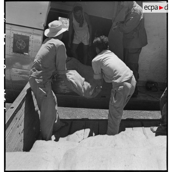  Chargement à bord d'un "Dakota" et largage de sacs de riz. Vues aériennes de Phnom Penh et de la zone de largage. [description provisoire]