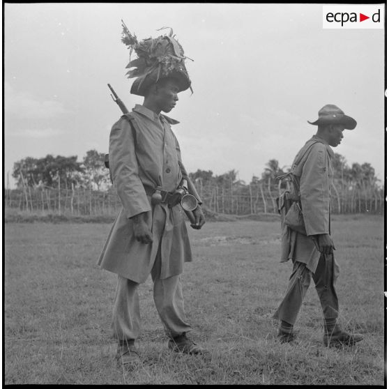 13 Deux porteurs : l'un, avec un sac à dos,du 3e BCC et l'autre, du 2/6e RIC, portant un sac sur sa tête. [description provisoire]