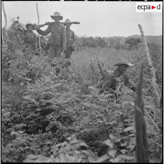 14 Des hommes du 3e BCC (3e Bataillon de Chasseurs Cambodgiens)  traversent un fossé recouvert de végétation. [description provisoire]