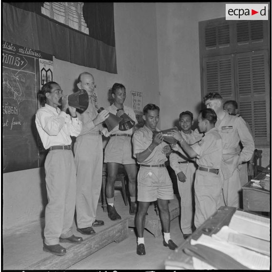 Au lycée Sisowath, lors d'un cours de formation de propagandistes militaires cambodgiens, un groupe expérimente le porte-voix métalliques de campagne, dont les 40 meilleurs élèves seront dotés à la sortie du cours. [description provisoire]