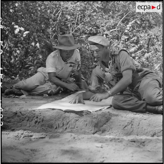 33 à 34 Le roi du Cambodge et le capitaine Hogart consultent une carte, au cours d'une pause. [description provisoire]