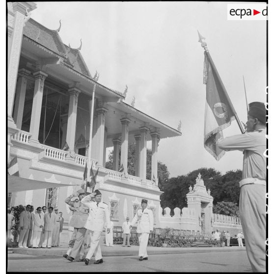Acompagné du général de Langlade, le roi Norodom Sihanouk salue le drapeau des FTC au cours de la présentation du bataillon devant le palais royal. [description provisoire]