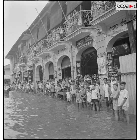 Civils cambodgiens dans la rue Ohier à Phnom Penh, après le passage d'un typhon. [description provisoire]