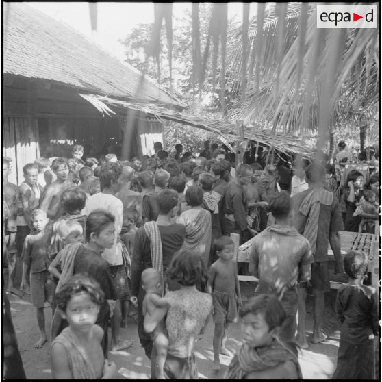 Au village d'Angkor-Chey, la population se presse autour de la table où sont distribués brochures et journaux par l'armée.