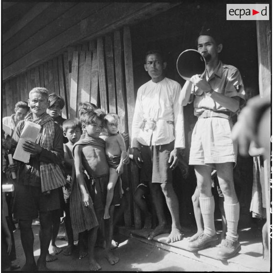 Au village d'Angkor Chey, un sous-officier parle à la population dans un mégaphone lors d'une tournée de propagande parmi les populations regroupées dans la province de Kampot.