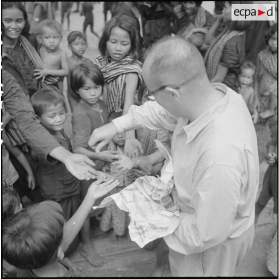 Distribution de bonbons aux enfants au cours d'une tournée de propagande parmi les populations cambodgiennes regroupées dans la province de Kampot