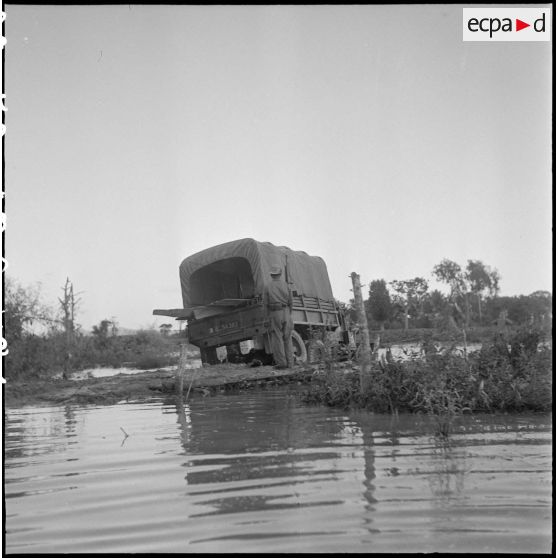 1à 6 Un convoi de GMC 6x6 est ralenti par les coupures de la piste et les inondations. [description provisoire]