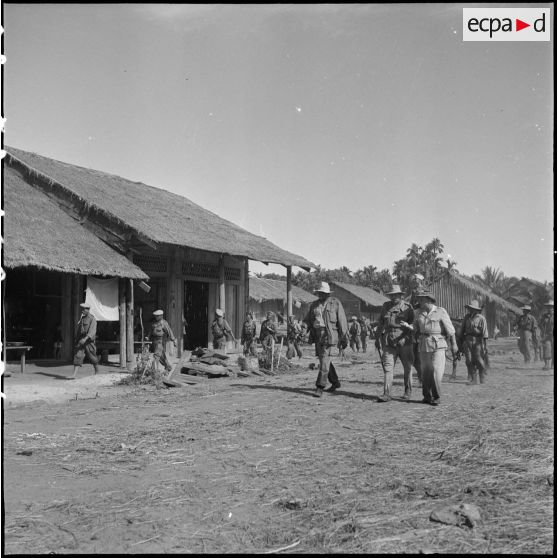 24 Le général Girot de Langlade et M. Gorce délégué de la province de Kompong Cham traversent le village de Kandol Kong. [description provisoire]