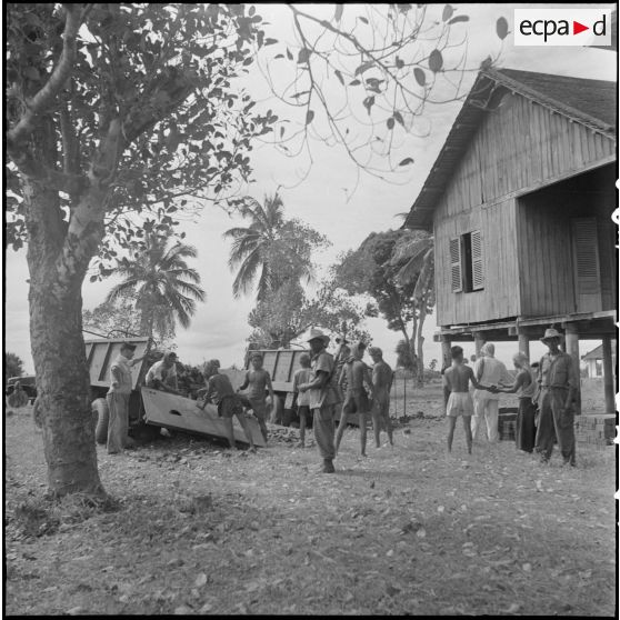 Les camions de briques en cours de déchargement pour la construction du cantonnement du BSPP (Bataillon de Sécurité de Phnom Penh) aux abords de l'aérodrome de Pochetong. [description provisoire]
