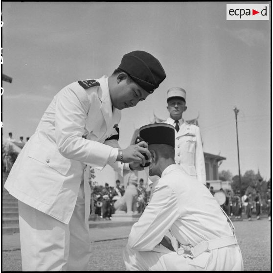3 Le roi du Cambodge, M. Norodom Sihanouk, remet les épaulettes d'officier à l'un des élèves de la promotion "Ly Yoeun". [description provisoire]