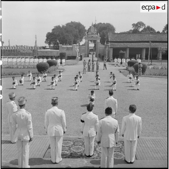 6 à 7 Plan d'ensemble des élèves officiers de la promotion, genou en terre, devant les autorités civiles et militaires. [description provisoire]