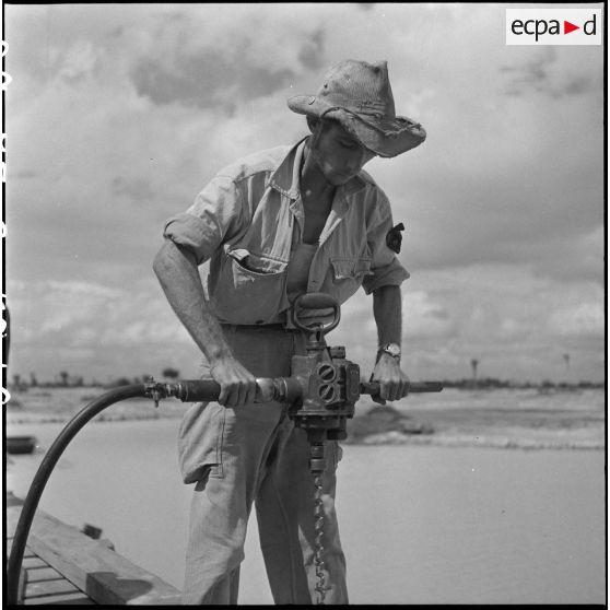 16 à 17 Plan rapproché sur l'utilisation d'une tarière à air comprimé et d'une scie à air comprimé. [description provisoire]