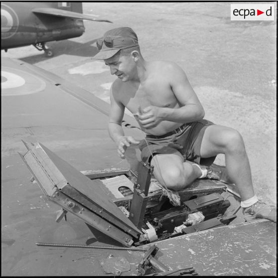 12 Un mécanicien démonte une mitrailleuse d'aile d'un avion Bearcat F8F. [description provisoire]