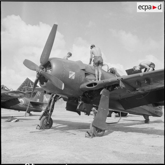 2 à 3 Deux mécaniciens effectuent la révision d'un avion Bearcat F8F à son retour de mission. [description provisoire]